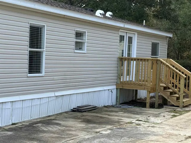 a view of a house with wooden deck