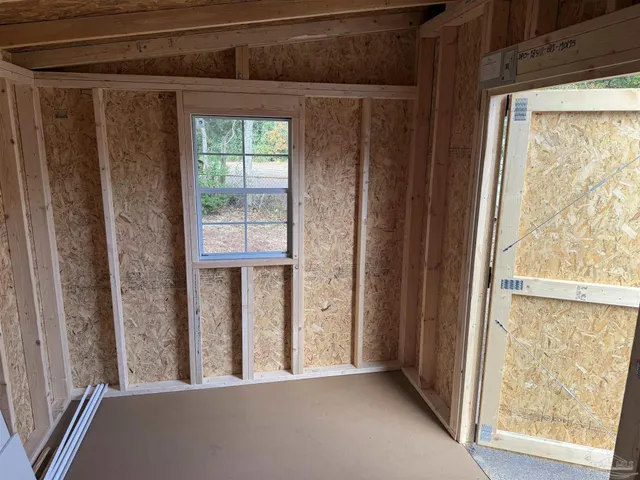 a view of a hallway with wooden floor and a window