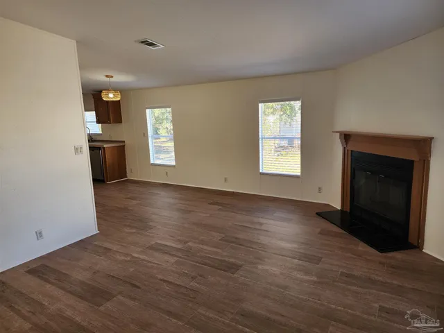 an empty room with windows and a fireplace
