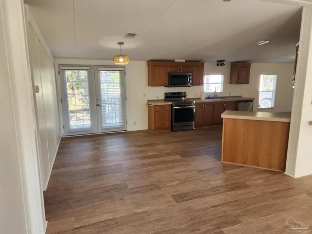 a view of kitchen with microwave a stove and wooden floor