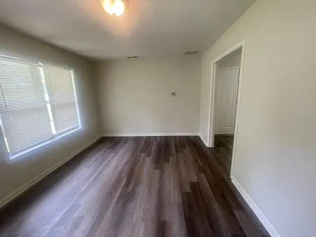 wooden floor in an empty room with a window