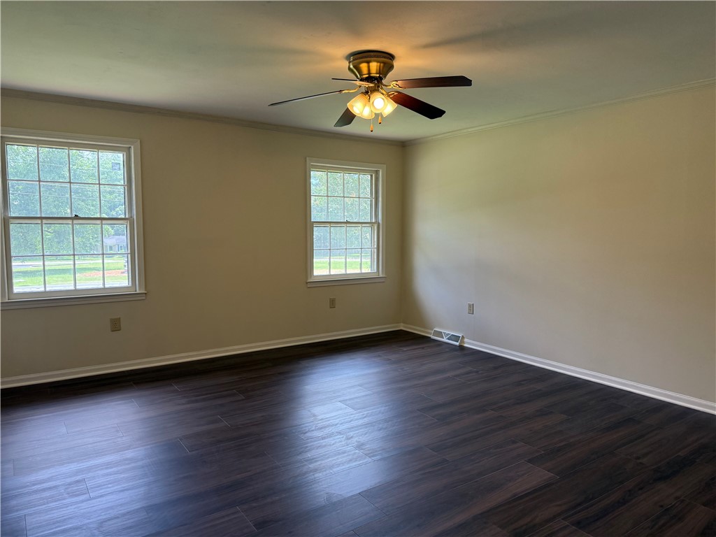 1507 East Calhoun Street Anderson, SC 29621 - Photo 15 of 18 Rich wood flooring and a refreshing ceiling fan elevate this generously sized sleeping space.