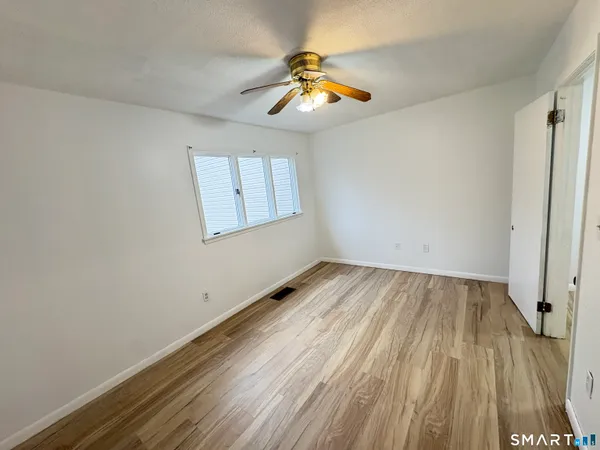 a view of empty room with wooden floor