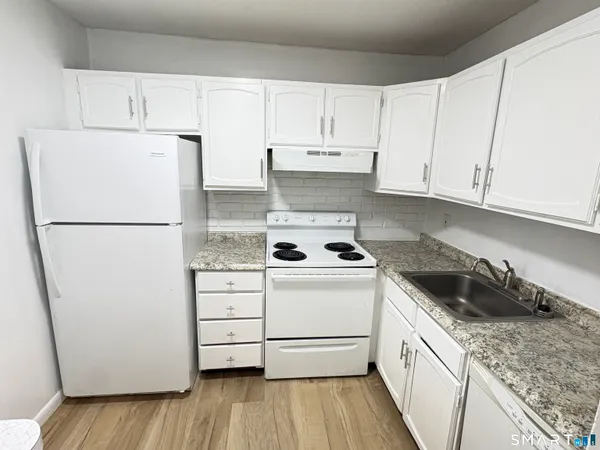 a kitchen with white cabinets and white appliances
