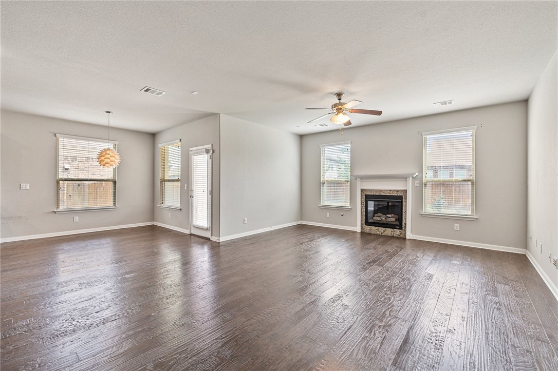 619 Palo Duro Loop Round Rock, TX 78664 - Photo 1 of 1 an empty room with wooden floor fireplace and windows