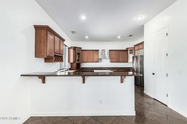 a view of an empty room with a kitchen and fireplace
