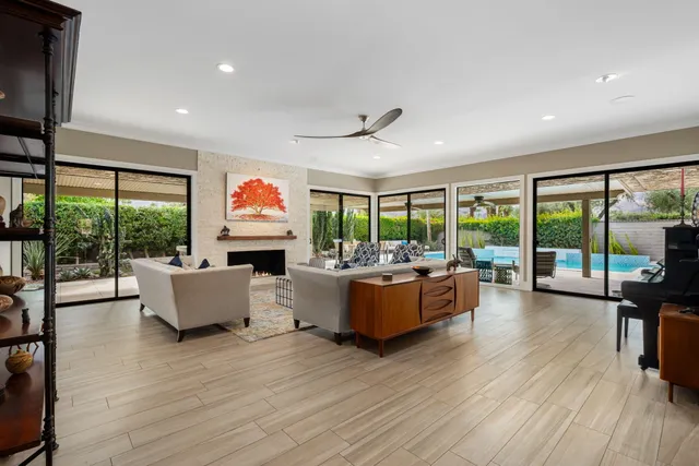 a living room with fireplace furniture and a large window