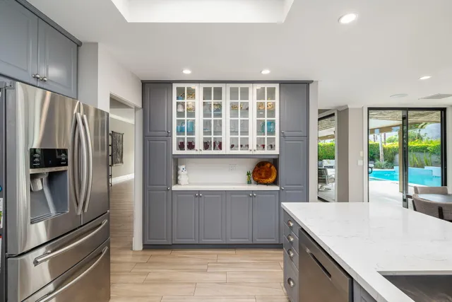 a kitchen with stainless steel appliances granite countertop a refrigerator and a sink