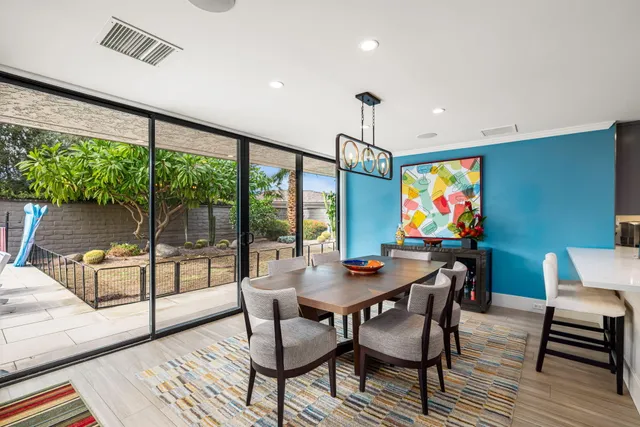 a view of a dining room with furniture a rug and wooden floor