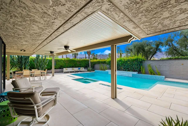 a patio with a table and chairs and potted plants