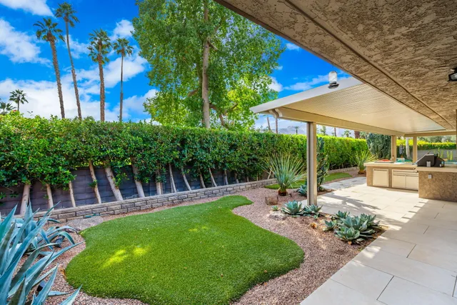 a view of a chair and table in backyard of the house