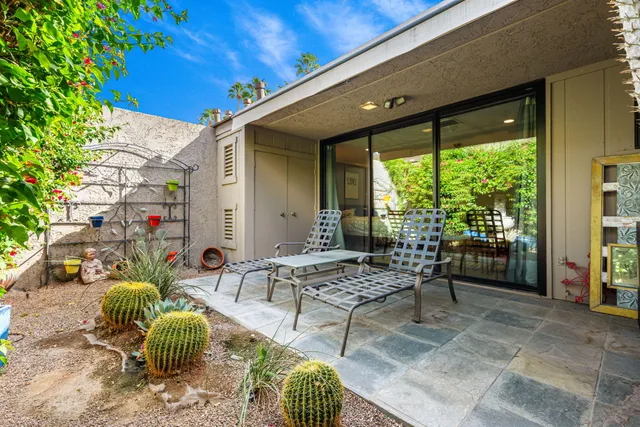 a living room with furniture large window and wooden floor