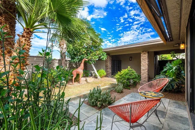 a view of a chair and table in backyard of the house