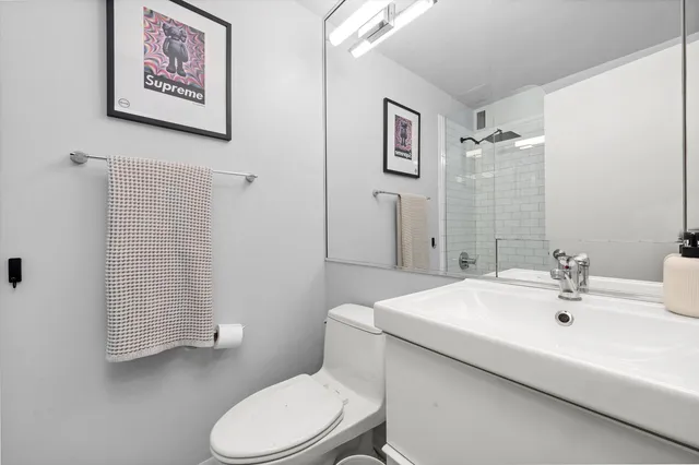 a bathroom with a sink mirror vanity and toilet