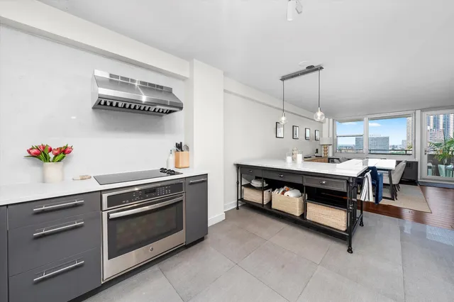 a kitchen with a sink dishwasher and white cabinets with wooden floor