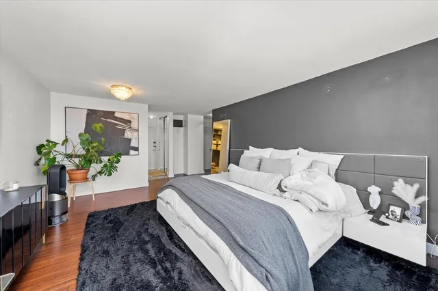 a spacious bedroom with a bed and a potted plant