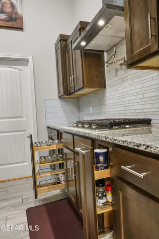a kitchen with stainless steel appliances granite countertop a sink a stove and a refrigerator