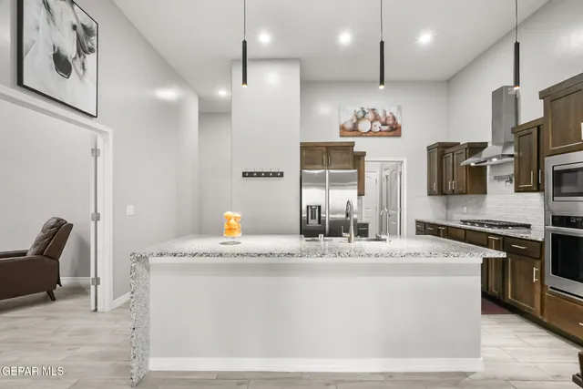 a kitchen with stainless steel appliances granite countertop a stove a sink and a refrigerator