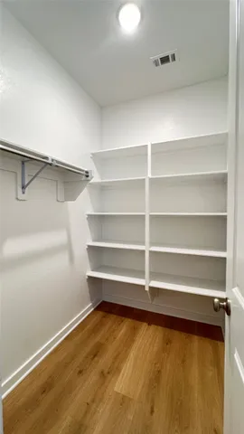 a view of walk in closet with empty racks