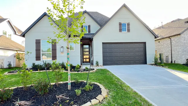 a front view of a house with a garden and plants