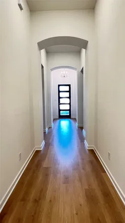 a view of a hallway with wooden floor
