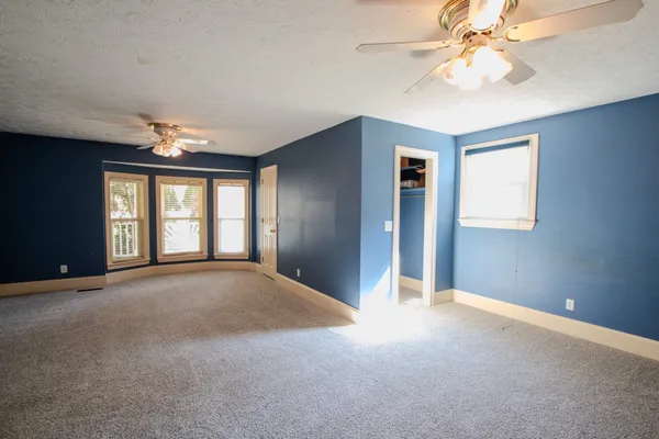 a view of a big room with chandelier fan