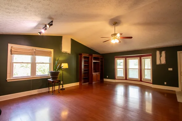 a view of an empty room with a chandelier fan