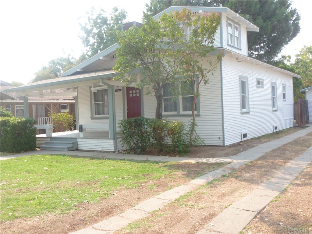 1044 West 20th Street Merced, CA 95340 - Photo 2 of 25 a view of a white house with a big yard and large tree