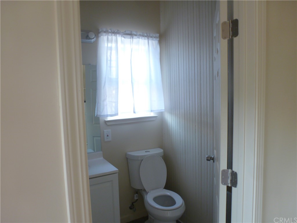 1044 West 20th Street Merced, CA 95340 - Photo 13 of 25 a bathroom with a toilet a sink and a window