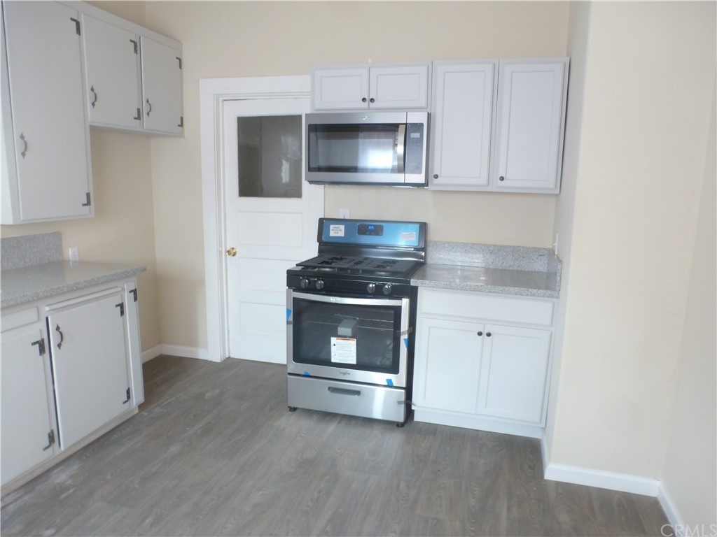 1044 West 20th Street Merced, CA 95340 - Photo 4 of 25 a kitchen with granite countertop white cabinets and stainless steel appliances