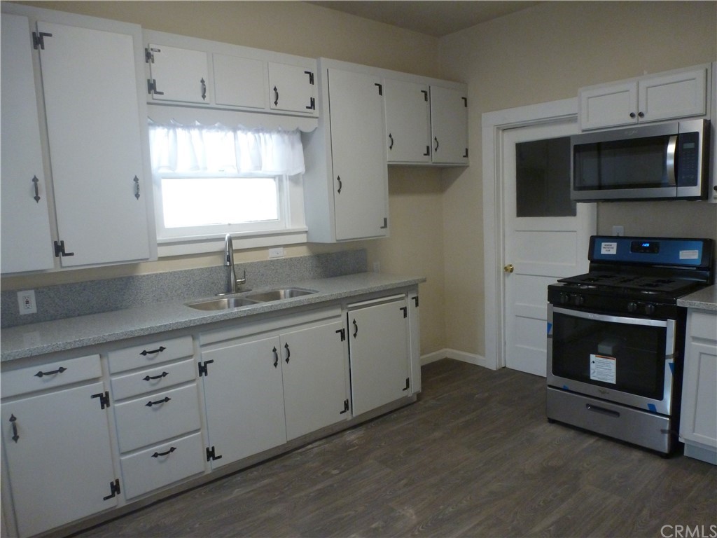 1044 West 20th Street Merced, CA 95340 - Photo 6 of 25 a kitchen with granite countertop white cabinets white stainless steel appliances and a sink