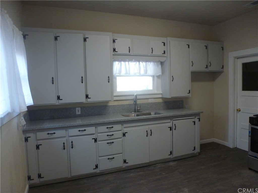 1044 West 20th Street Merced, CA 95340 - Photo 7 of 25 a kitchen with white cabinets and sink