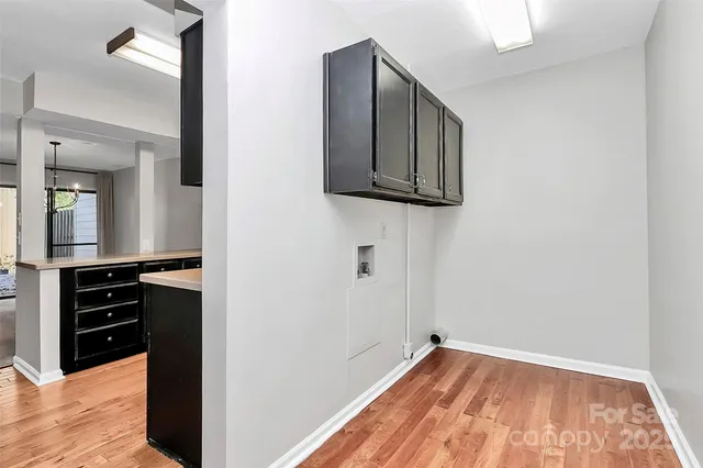 a view of a hallway with wooden floor and cabinet