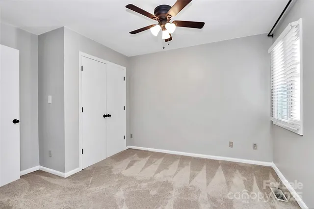 a view of a room with a ceiling fan and a window