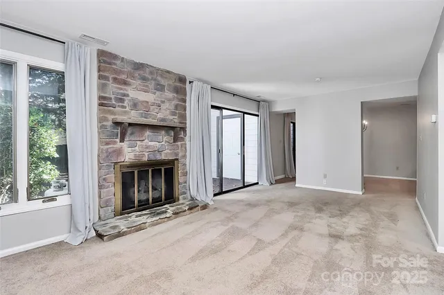 a view of an empty room with window and fire place
