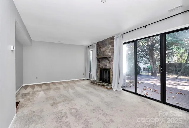 an empty room with floor to ceiling window and an empty room