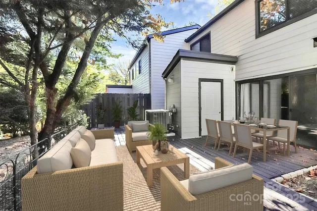 a view of a patio with couches table and chairs and potted plants