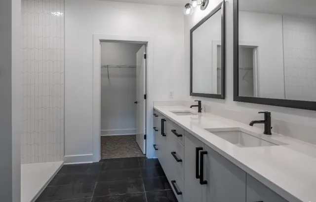 a bathroom with double vanity and mirrors