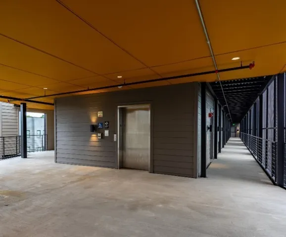 a view of a hallway with wooden wall and door