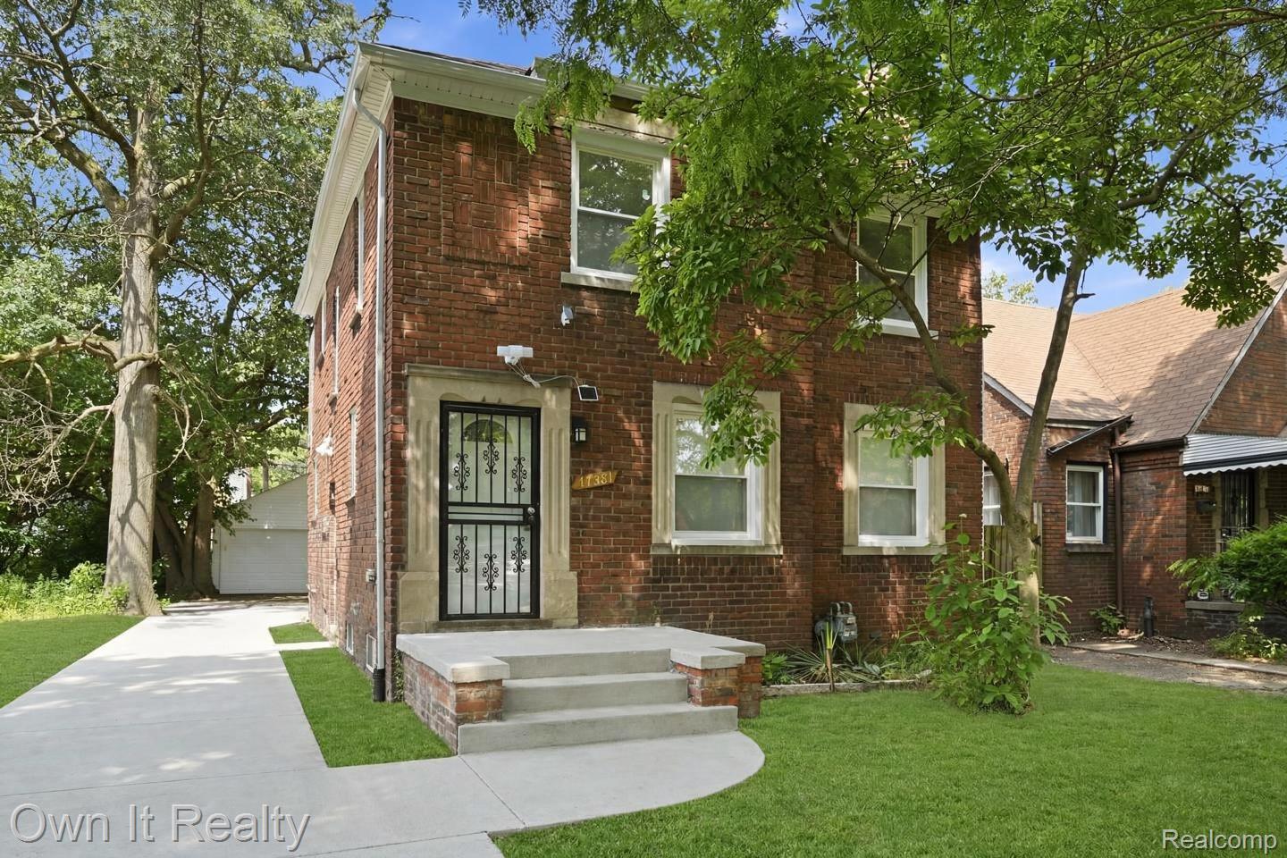 17351 Appoline Street Detroit, MI 48235 - Photo 2 of 34 Brick exterior with white window trim and a decorative security storm door