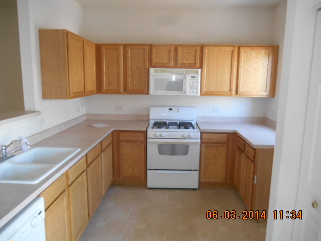 132 Enclave Circle, Unit D Bolingbrook, IL 60440 - Photo 5 of 9 a kitchen with a sink stove and cabinets