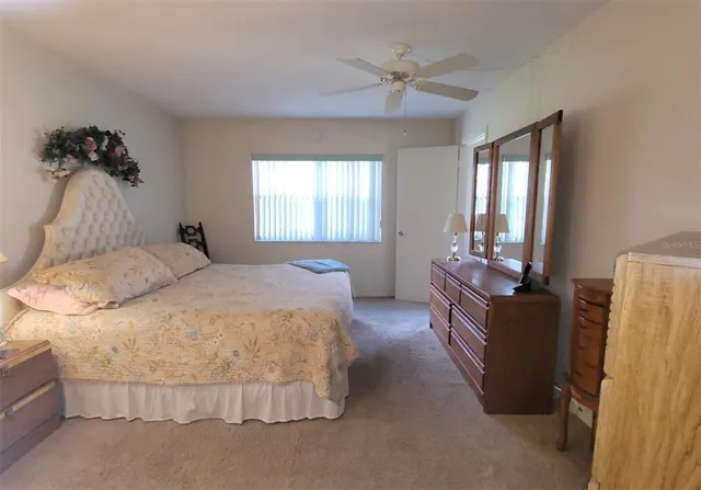 a bed sitting in a bedroom next to a lamp