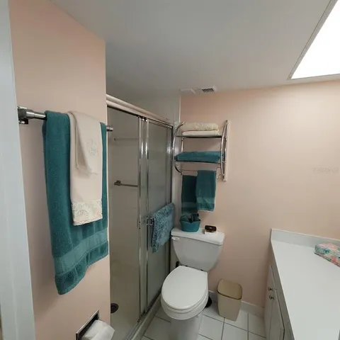 a bathroom with a toilet sink washing machine and mirror