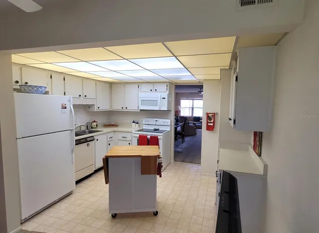 a kitchen with a stove top oven a sink and a refrigerator