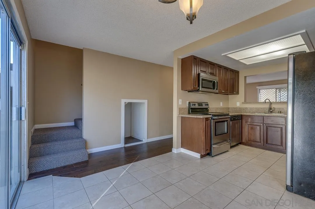 948 Gillespie Drive Spring Valley, CA 91977 - Photo 18 of 20 a kitchen with stainless steel appliances granite countertop a refrigerator and a stove top oven