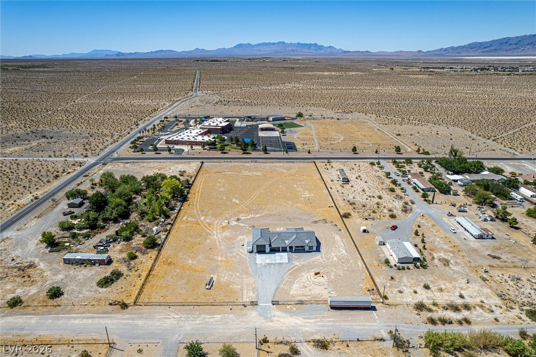 5910 East Kellogg Road Pahrump, NV 89061 - Photo 47 of 58 An aerial perspective showcases a new desert build, presenting ample undeveloped acreage for expansion.