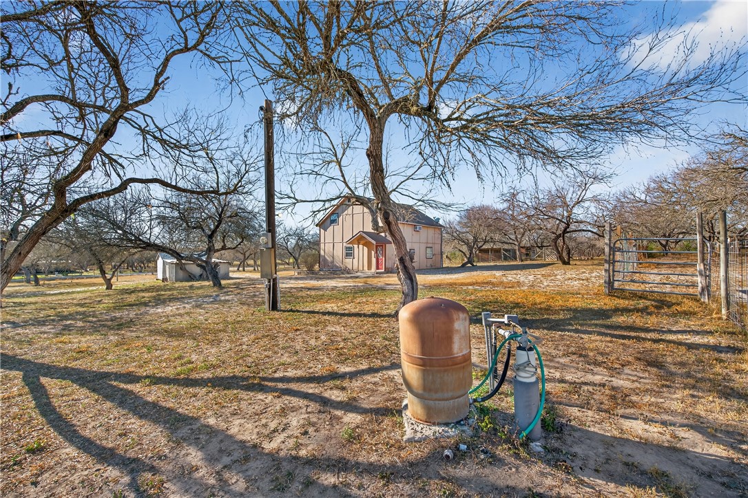 5752 Mockingbird Lane Mathis, TX 78368 - Photo 10 of 35 a backyard of house with trees and outdoor seating