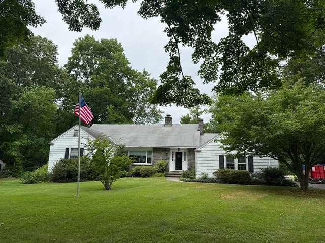 a view of a house with a yard and sitting area