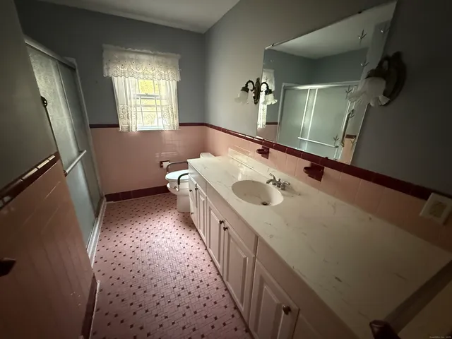 a bathroom with a sink a toilet and mirror