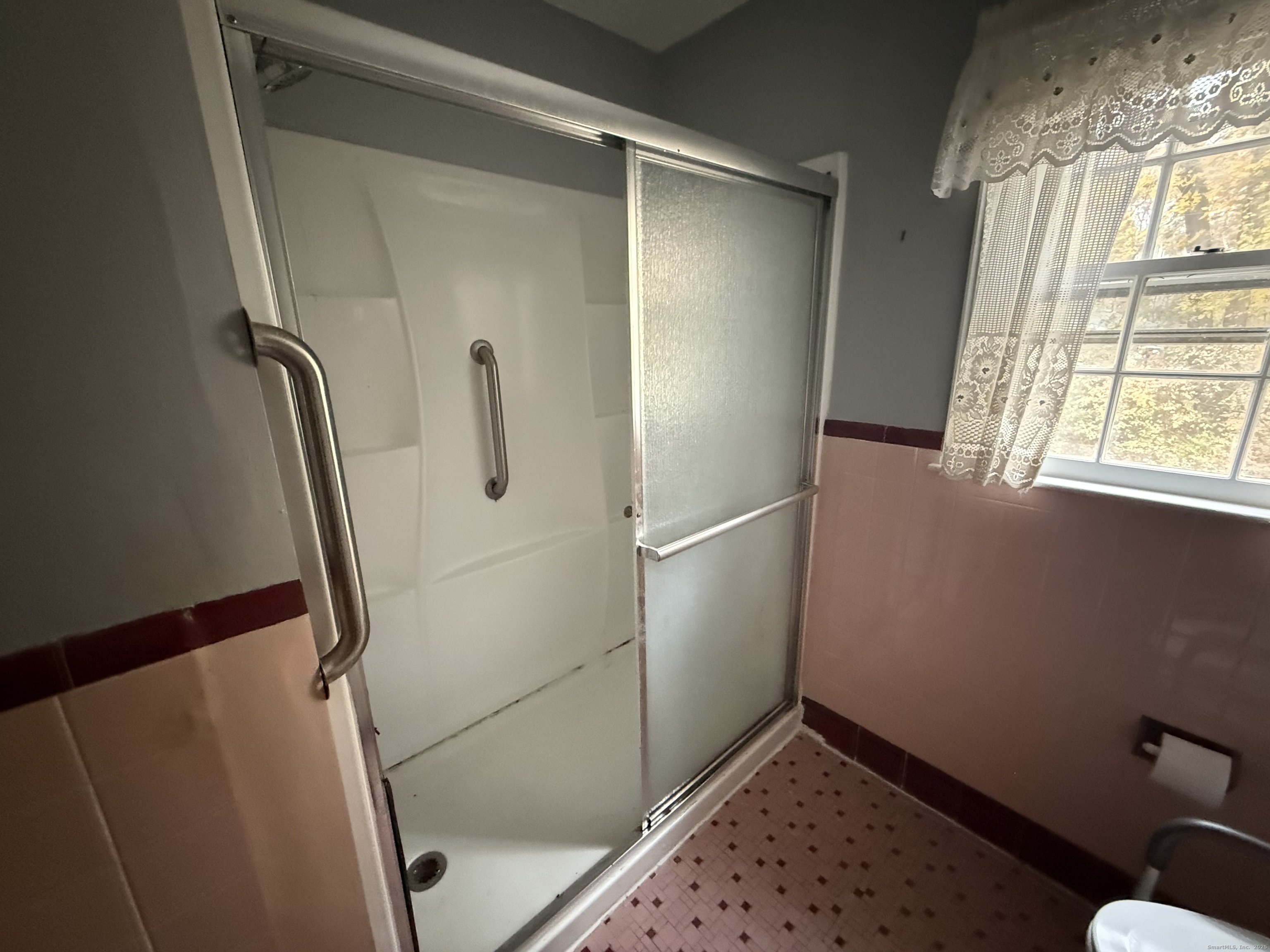 8 Nelson Place Fairfield, CT 06825 - Photo 14 of 32 a view of walk in closet with window and wooden floor